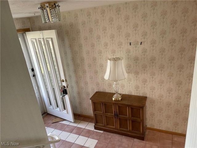 foyer with light tile patterned floors, baseboards, and wallpapered walls