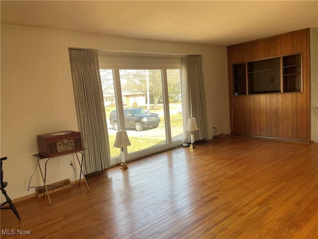 spare room featuring visible vents, baseboards, and wood finished floors