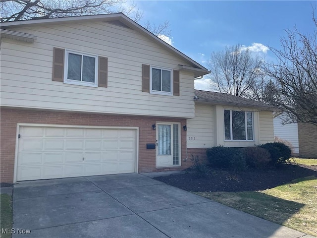 tri-level home with brick siding, an attached garage, and driveway