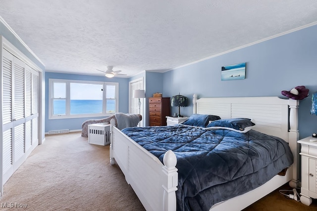 bedroom featuring ornamental molding, a textured ceiling, a ceiling fan, and carpet floors