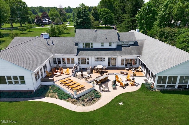 rear view of property with a yard, an outdoor living space with a fire pit, and outdoor dining space