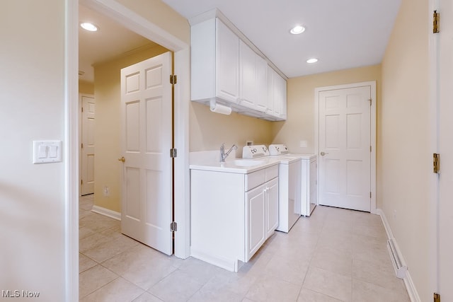 laundry room featuring a sink, recessed lighting, cabinet space, light tile patterned floors, and baseboards