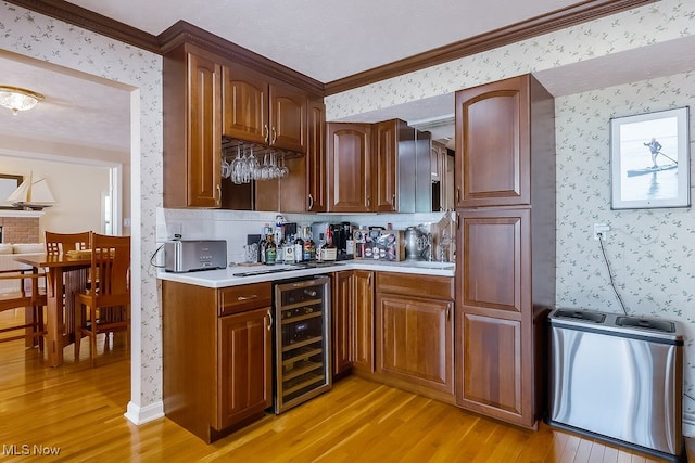 kitchen with wallpapered walls, light countertops, beverage cooler, and light wood-type flooring