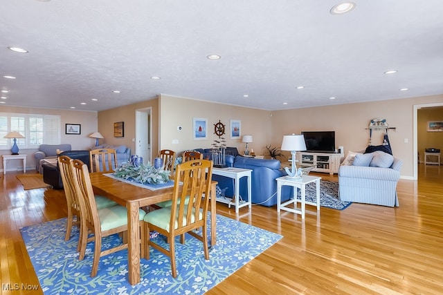 dining area featuring recessed lighting, light wood-style flooring, and a textured ceiling