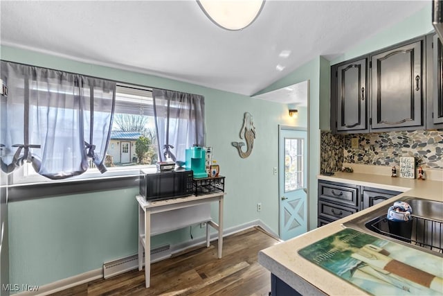 kitchen with plenty of natural light, backsplash, a baseboard heating unit, and black microwave