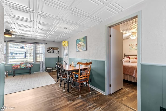 dining room with wainscoting, an ornate ceiling, and wood finished floors