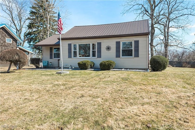 view of front of house with metal roof and a front lawn