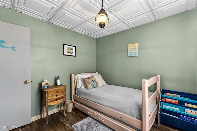 bedroom featuring baseboards, an ornate ceiling, and dark wood-style floors