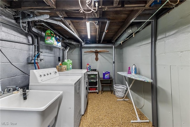 clothes washing area with laundry area, washing machine and dryer, and a sink