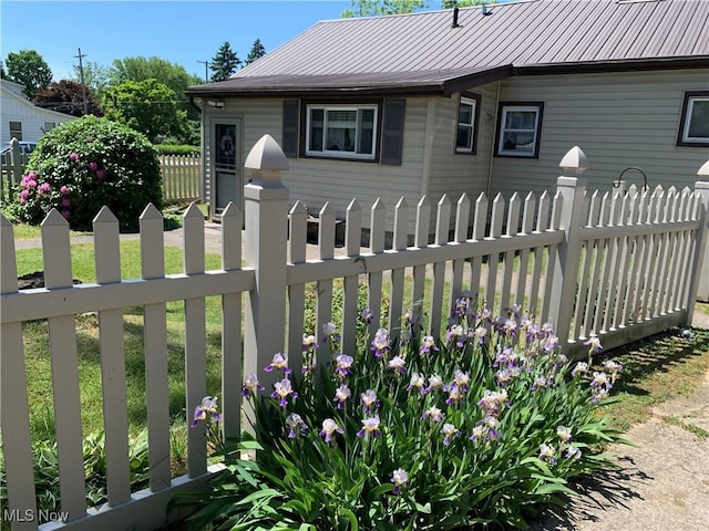 view of front of property featuring metal roof and fence