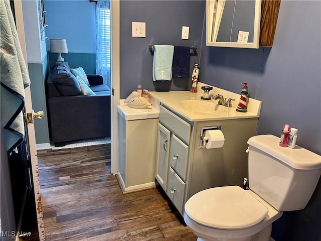 bathroom with toilet, wood finished floors, and vanity