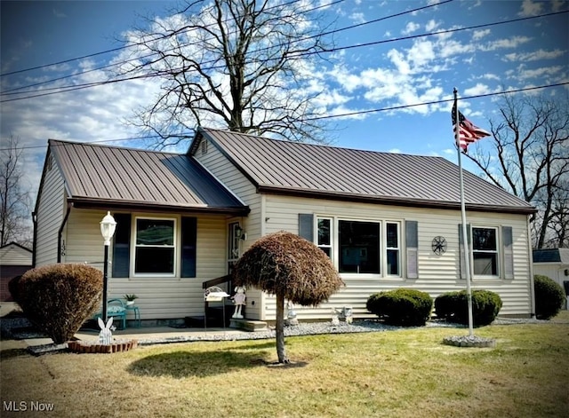 view of front of house featuring a standing seam roof, a front yard, a patio area, and metal roof