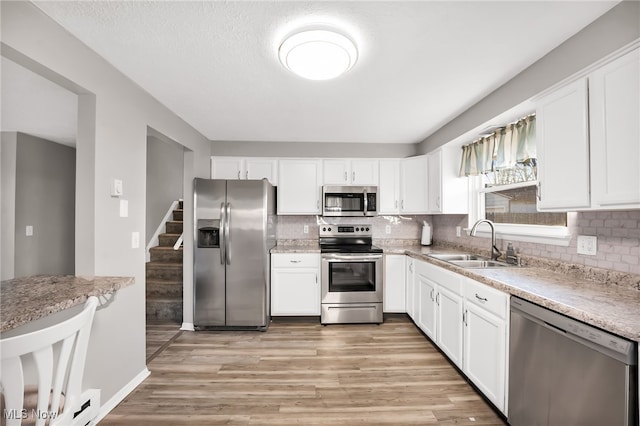 kitchen with a sink, appliances with stainless steel finishes, and white cabinets