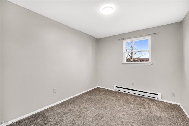 spare room with a baseboard heating unit, baseboards, and carpet