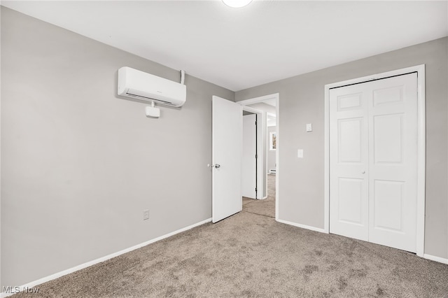 unfurnished bedroom with a closet, baseboards, a wall unit AC, and carpet floors