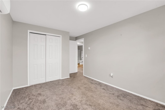 unfurnished bedroom featuring carpet, a closet, and baseboards