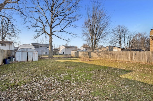 view of yard featuring an outbuilding, a storage unit, and a fenced backyard