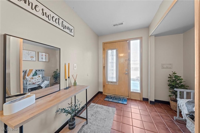 tiled entrance foyer featuring visible vents and baseboards