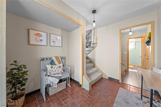 living area featuring dark tile patterned floors, stairway, and baseboards