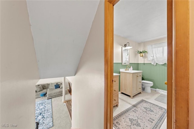 bathroom featuring wainscoting, toilet, and vanity