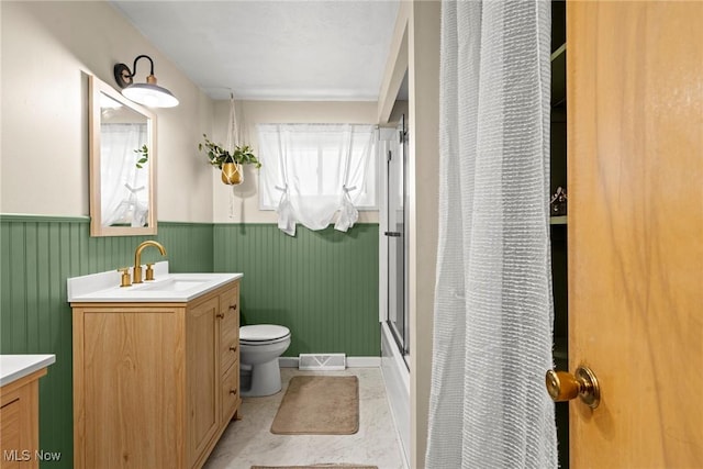 full bath with visible vents, a wainscoted wall, toilet, a shower with shower curtain, and vanity