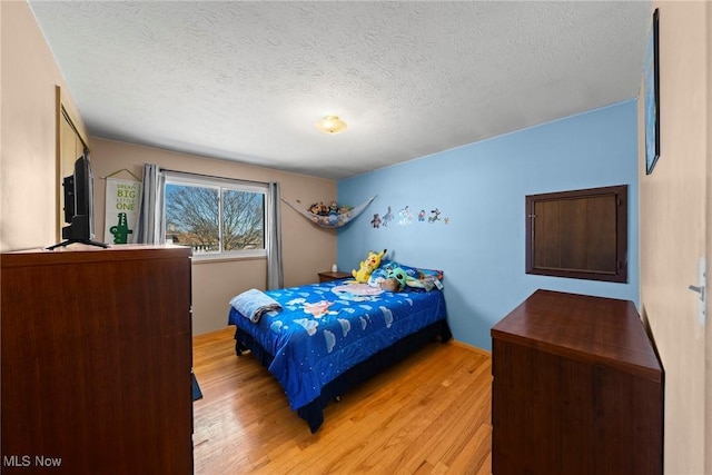 bedroom featuring light wood-style floors and a textured ceiling