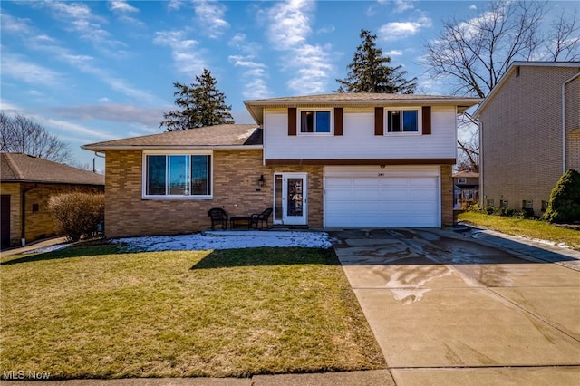 tri-level home featuring concrete driveway, an attached garage, brick siding, and a front lawn