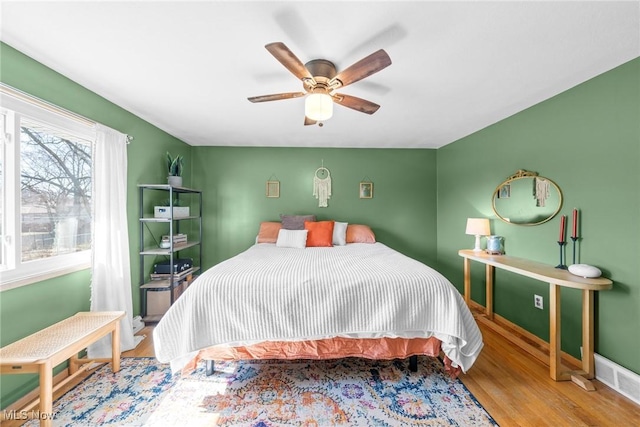 bedroom with baseboards, a ceiling fan, and wood finished floors