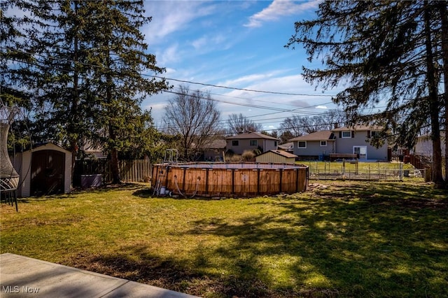 view of yard with a fenced in pool, fence, an outdoor structure, and a shed