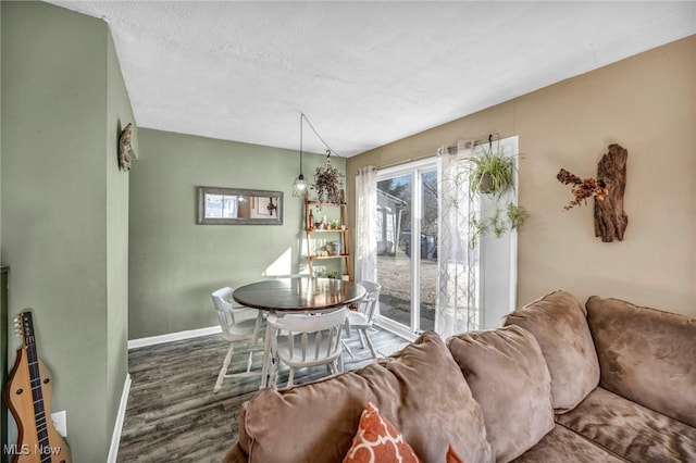 dining room with wood finished floors, baseboards, and a textured ceiling