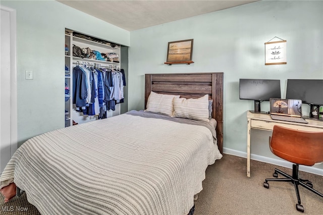 carpeted bedroom featuring baseboards and a closet