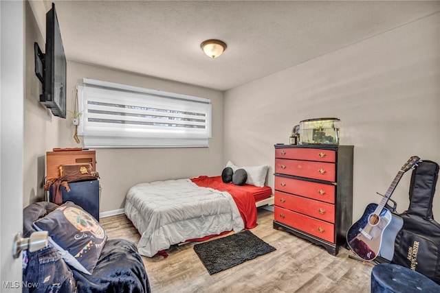 bedroom featuring wood finished floors and a textured ceiling