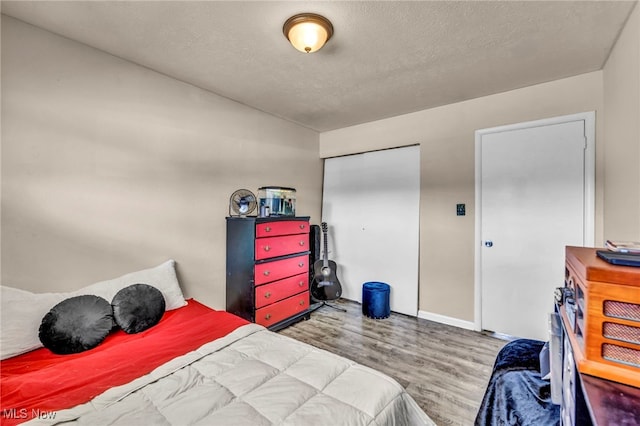 bedroom with a textured ceiling and wood finished floors