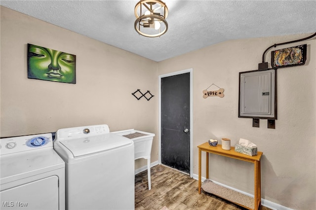 laundry area with electric panel, laundry area, wood finished floors, independent washer and dryer, and a textured ceiling