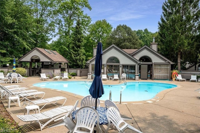 pool featuring fence and a patio area