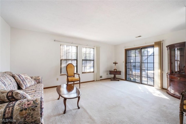 sitting room featuring visible vents, a textured ceiling, baseboards, and carpet floors