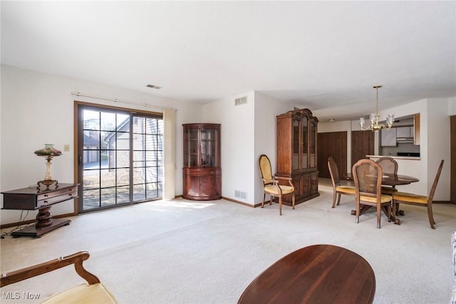 living area featuring carpet flooring, visible vents, and a chandelier