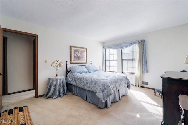 carpeted bedroom with visible vents and baseboards