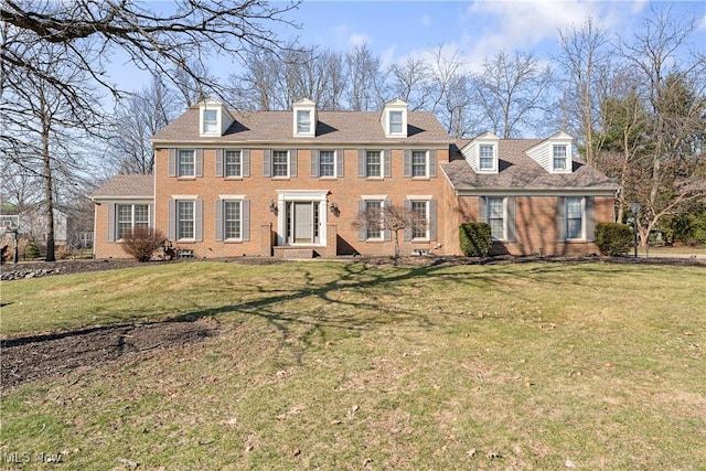 view of front facade with brick siding and a front lawn