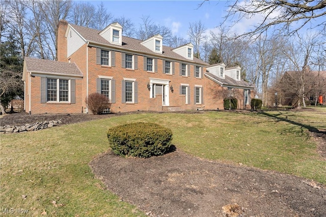 view of front of property with a front yard and brick siding