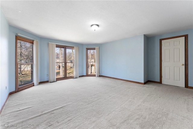 empty room with baseboards and carpet flooring