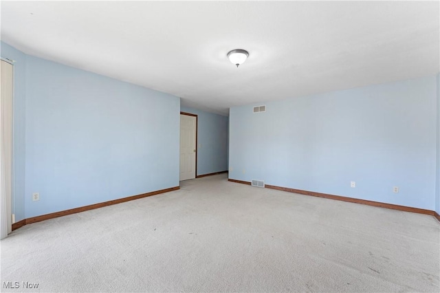 empty room with visible vents, baseboards, and light carpet