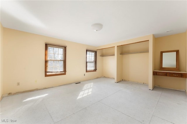 unfurnished bedroom with visible vents and multiple closets