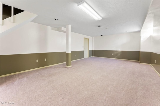 unfurnished room with baseboards, carpet flooring, a textured ceiling, and visible vents