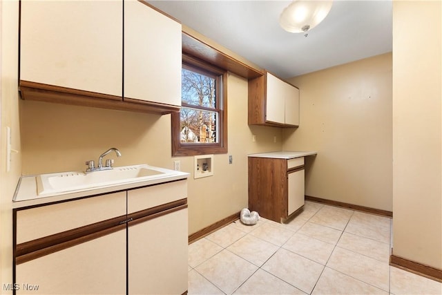 laundry room featuring a sink, cabinet space, light tile patterned flooring, baseboards, and hookup for a washing machine