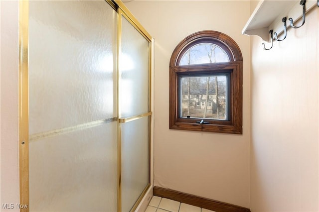 corridor with light tile patterned floors and baseboards