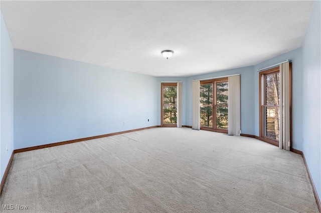 carpeted empty room with baseboards