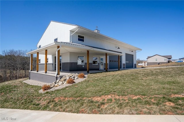 back of house featuring covered porch, an attached garage, a lawn, and metal roof