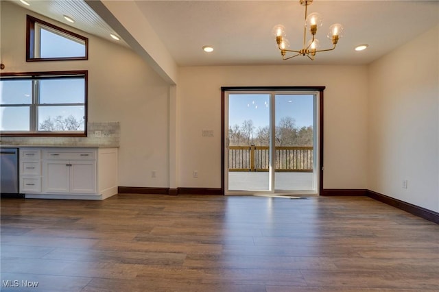 unfurnished dining area featuring wood finished floors, a healthy amount of sunlight, and baseboards