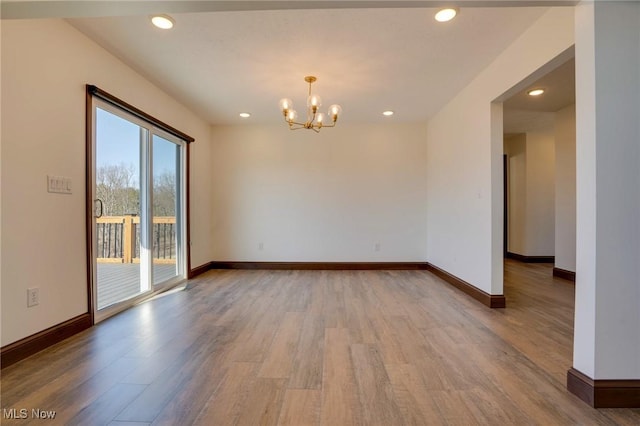 spare room with recessed lighting, baseboards, and wood finished floors